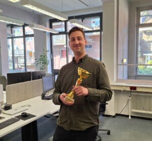 Erik heeft een wisseltrofee in zijn handen.