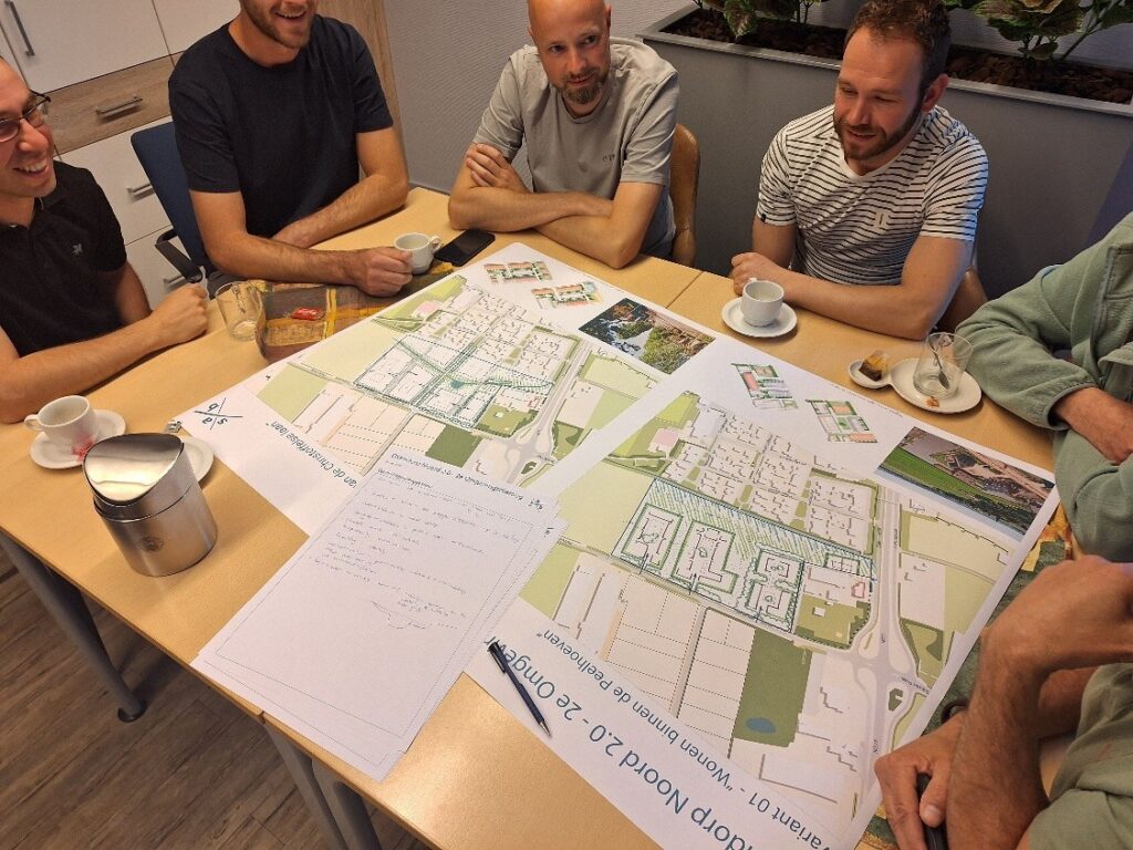 Inwoners van Elsendorp met elkaar in gesprek rond een tafel waarop kaarten met verschillende stedenbouwkundige varianten liggen